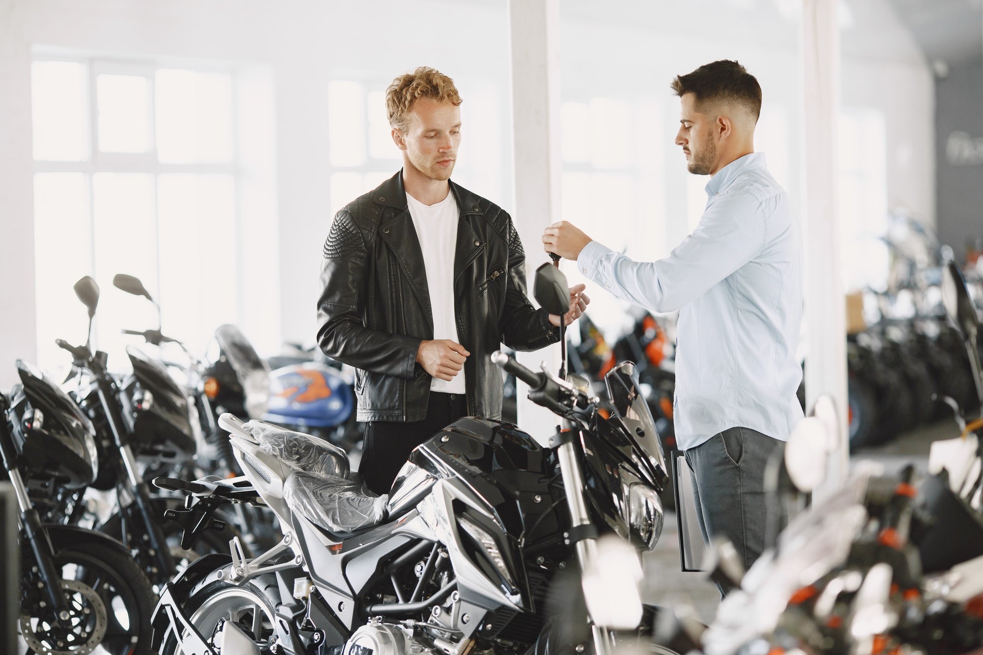 man-choosed-motorcycles-moto-shop-guy-black-jacket-manager-with-client